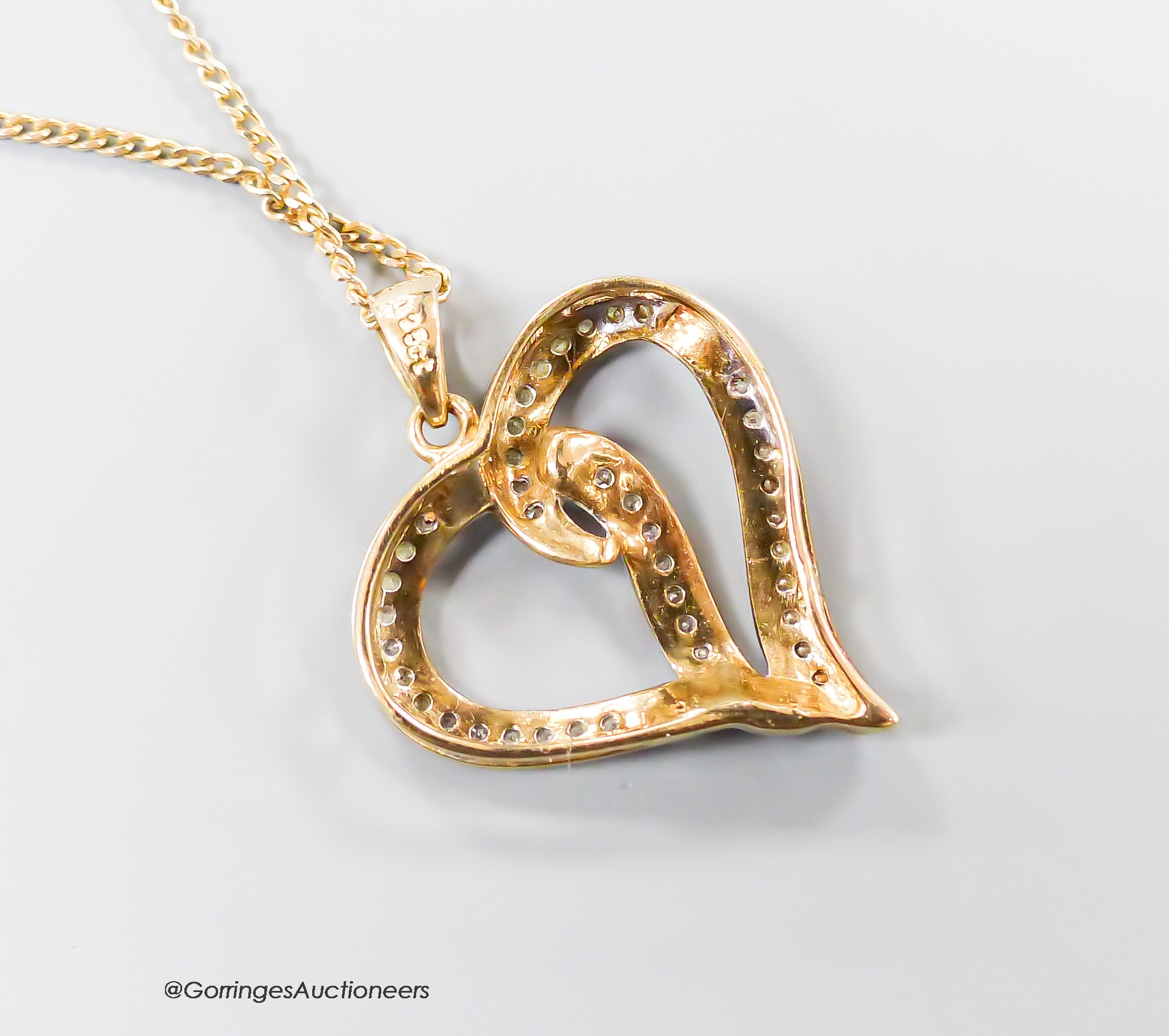 A modern 375 and diamond chip set openwork heart pendant, 22m, on a 9ct gold fine link chain, 46cm, gross weight 3.7 grams.